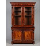 A Victorian mahogany bookcase raised on a single drawer cupboard base with carved scrolling corbels,