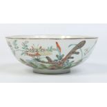 A Chinese bowl. Painted in coloured enamels with a landscape incorporating butterflies and flowers.