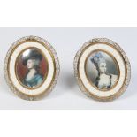 A pair of 20th century portrait miniatures in oval brass filigree strut frames, 13.5cm.