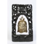 A 19th century Oriental bronze prayer gong raised on a carved and pierced hardwood stand with