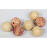 Seven small 19th century turned ivory billiard balls, three stained in ox blood. 346 grams, 3.