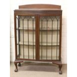 A mahogany bow front astrigal glazed china display cabinet raised on ball and claw feet.