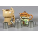 An English pewter three part tea service along with a Burlington Cottage ware teapot and a novelty