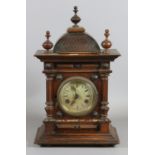 A mahogany cased bracket clock chiming on a coiled gong.