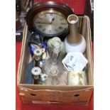 A box of miscellaneous including a pair of glass decanters, a wall clock, toby jug,