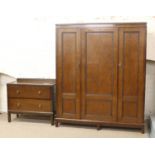 A carved oak two part bedroom suite consisting of triple wardrobe and matching two drawer chest