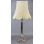 A silver plated Corinthian column based tablelamp and shade.