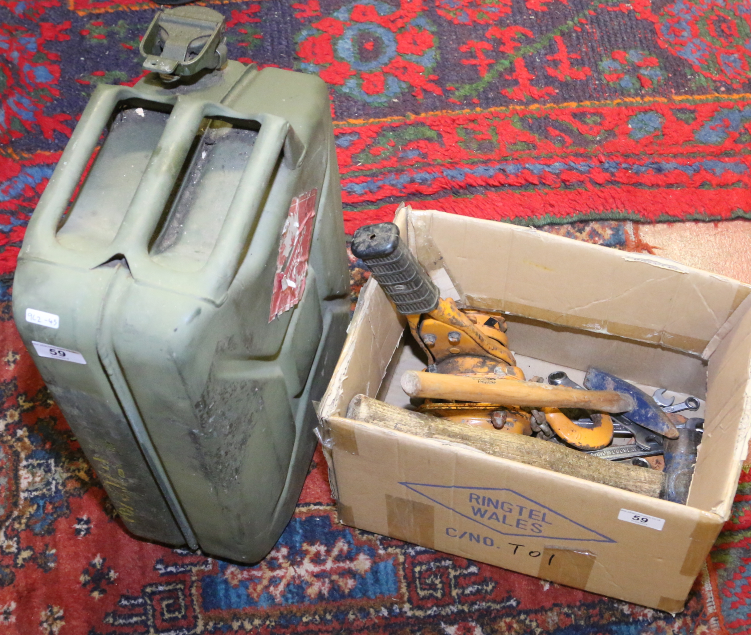 A jerry can and box of tools including a hoist, lump hammer, various spanners, etc.