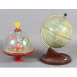 A childs spinning top along with a tinplate globe.