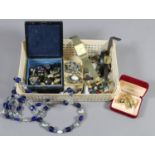 A box of mixed costume jewellery including earrings, gold plated brooch, wristwatches and beads,