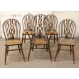 A set of four plus one carver arm wheelback dining chairs.