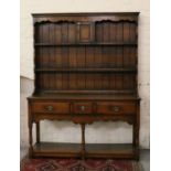 A Titchmarsh & Goodwin carved and panelled oak dresser raised on turned legs.