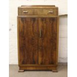 A walnut tallboy with Art Deco handles, top drawer and fitted interior. Condition Report.