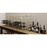 A collection of mixed wines and spirits along with various wire framed bottle racks.