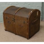 A metal bound reinforced canvas dome top travel trunk with wood and leather trim and bearing