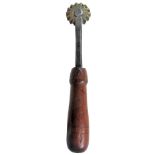 An American pastry jigger with brass wheel, the square section iron stem having chamfered edges,