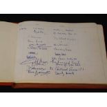 Visitor book in red leather, the first of 17 signed entries is dated and signed by 'L.S. Lowry,