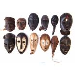 Twelve African passport masks carved in various tribal styles, the largest measures 19cm high All