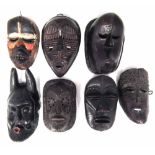 Seven African masks carved in various tribal styles, the largest measures 29cm high All lots in this