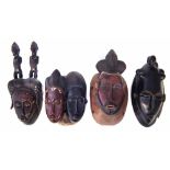 Baule mask carved with two figures and three other masks, 39cm high All lots in this Tribal and