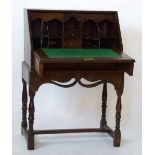 George III oak bureau on stand, the fall revealing a stepped interior over two short drawers, on