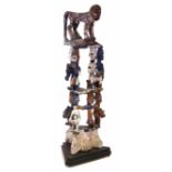 Urhobo dance crest, carved with three layers of painted figures topped by a leopard, 96cm high All