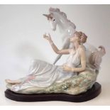 Lladro Goddess and Unicorn and Lady figure group, with wood base, 27cm high Condition report: One