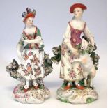 Two Derby figures of ladies circa 1770, modelled standing in front of floral bocages on scrolled