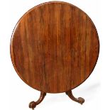 Rosewood circular tip top table on an octagonal baluster column and scrolled legs, diameter 135cm.