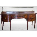 Sheraton Revival mahogany serpentine kneehole sideboard with a brass rail back on square section