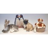 Four Royal Copenhagen animals, to include a pug dog, basket of puppies, pair of penguin and a