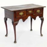 Walnut side table of three apron drawers and a shaped frieze on cabriole legs and pad feet, width