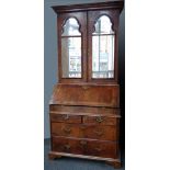 Walnut bureau bookcase, the upper part of two bevelled mirror doors enclosing shelves, and two