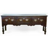 Oak dresser base of three short drawers with replacement brass plates on turned baluster legs,