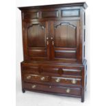 Montgomery oak press of raised panel doors over two short and one long drawer, width 138cm.