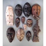 Twelve African passport masks carved in various tribal styles, the largest measures 23cm high All