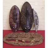 Two Papua New Guinea masks a carved tablet and one other figural post the largest measures 72cm high