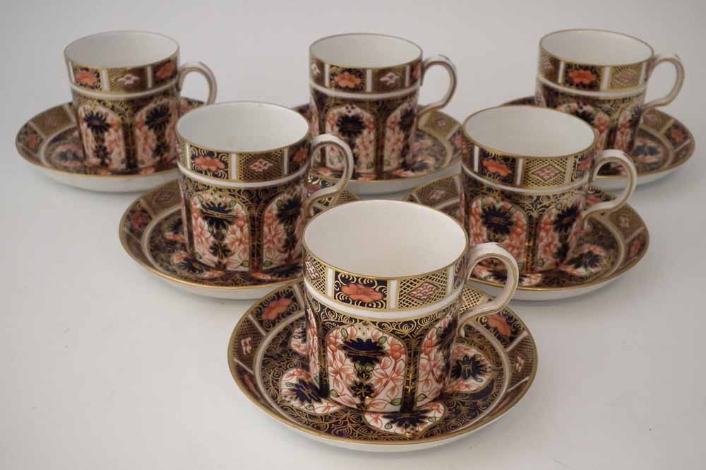 Six Royal Crown Derby coffee cups and saucers, decorated with imari 1128 pattern, date codes ranging