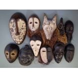 Eleven African masks carved in Lega, Chokwe, Songye, Baule, Dan and other tribal styles, the largest