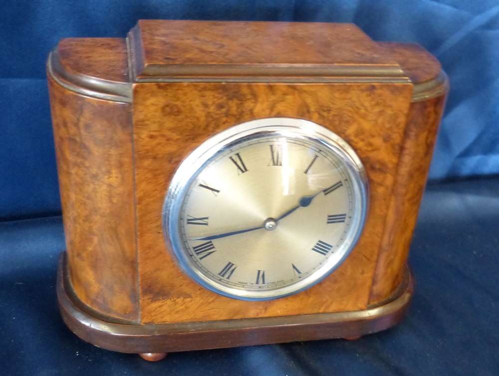 A Burr Walnut Timepiece having silvered dial with Roman numerals on bun feet,