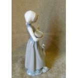 A Lladro Figure of a Young Lady carrying a bird in a basket,