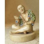 An Oriental Figure of a seated Gentleman on round base,