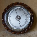 A 1930's Oak Hanging Round Barometer having rope style rim with silvered dial,