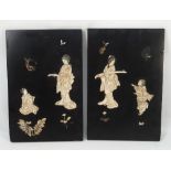 A pair of ebonised panels, decorated in the shibayama style with Japanese figures and foliage,