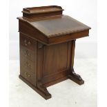 An Edwardian walnut Davenport, with rising lid,