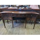 A mahogany sideboard, of serpentine form, with reeded border and an arrangement of drawers,