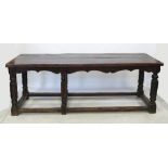 An Antique style oak refectory table, with shaped apron,