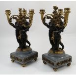 A pair of cast candelabra, three ormolu mounts supported by three putti,