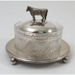 A silver and glass butter dish, of circular form, the silver lid with cow finial,