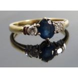 A sapphire and diamond three stone 18ct gold ring, the oval cut approximately 6mm x 5.